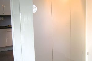 Garderobe- Schrankblock in weiß Hochglanz, in Grifflose TouchOpen Ausführung, ein Schrankteil abgeschrägt