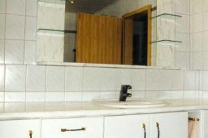 Badezimmermöbel mit Spiegelschrank- Überbau in Rundkantenfronten HPL Esche weiß. Waschtisch und Kranzplatte in HPL weiß glanz marmoriert