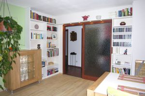 Bücherregal in MDF- Weißlack mit Türenüberbau über Eck, mit Vitrine in Eiche massiv Leimholz natur