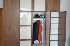 Garderobe- Nischenschrank in amerik. Nussbaum furniert mit Nussbaumrahmen mit Hochglanzfüllung cremefarben