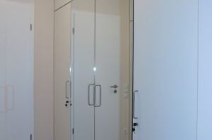 Garderobe- Einbauschränke in Fronten Weiß perl mit Alukanten beleimt an zwei Zimmerwänden