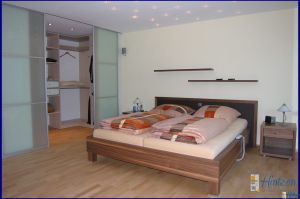 Bettanlage in Nußbaum-Linol und begehbarem Ankleidezimmer eigener Fertigung