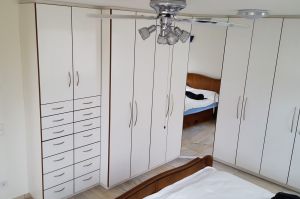 Schlafzimmer- Schrankwand über Eck in Dekorplatte weiß streep mit Starkkanten in Nussbaum beleimt (als komplette Raumlösung zum bauseitigen Nussbaum Bett)