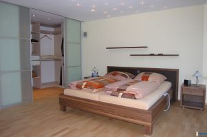 Schlafzimmereinrichtung als Bett in Nußbaum (unserer Fertigung) mit begehbarem Holzkorpus- Ankleidezimmer und Gleittüren