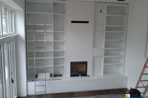 TV- Bücherregal in "Stollenbauart" MDF- Weißlack mit mittig integriert eingebautem Kamin.