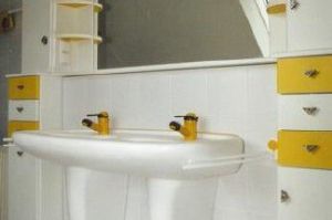 Badezimmermöbel in Rundkantenfronten HPL weiß und gelb. Kranzplatte in HPL mit Halogenbeleuchtung