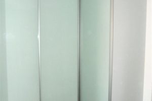 Gleittüren Alu A17, Füllung Glas rückseitig weiß lackiert mit Alu-Einrichtungssystem an drei Wänden des Raumes über Eck laufend