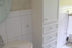 Badezimmerschrank in Weißlackfront mit Zierprofil