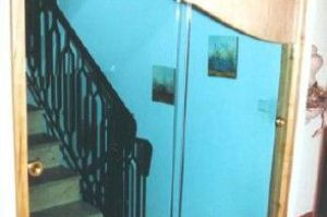 Maßgefertigte Treppenhaus- Schiebetüranlage in Erle furnierter Sonderform mit elegant geschwungenem Glasauschnitt