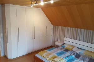 Schlafzimmer- Dachschrägenschrank in cremeweiß Brillant Hi-Gloss, mit Edelstahl- Relinggriffe
