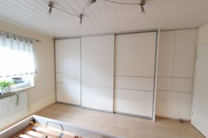Alusystem- Schlafzimmerschrank mit Gleittüren in Weißlack (Mit Schrankrücksprung im Zimmertürbereich)