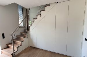 Maßgefertigter Großraumschrank mit passgenauer Treppenanpassung in Weißlack Ral 9010